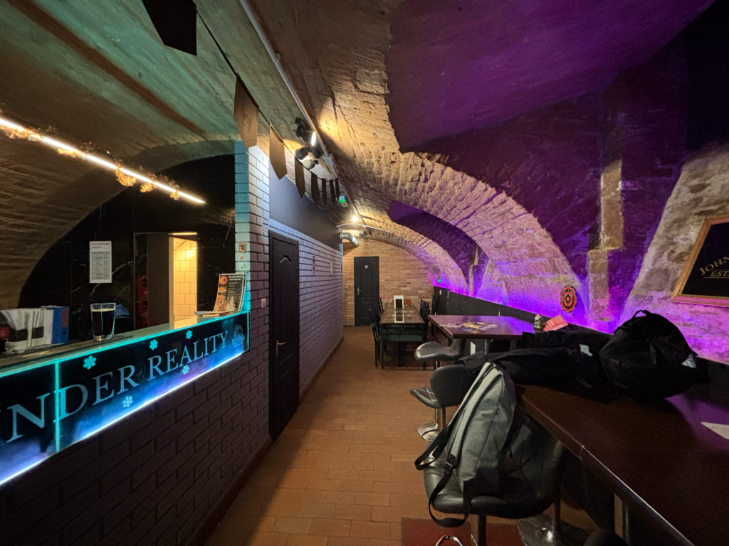 A The Black Door Darts & Sport Bar bárpultja csapolt sörökkel, italválasztékkal és hangulatos pincehelyiséggel.