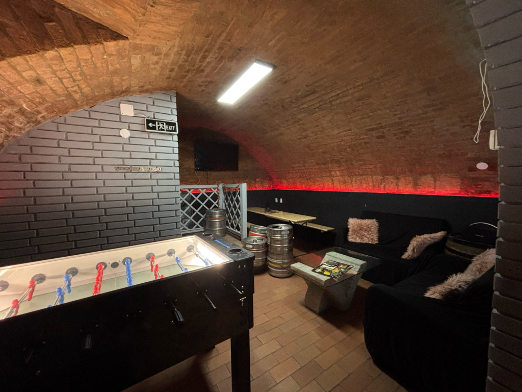 Csocsóasztal és kényelmes lounge rész sportközvetítésekhez és baráti összejövetelekhez a The Black Door Darts & Sport Barban.
